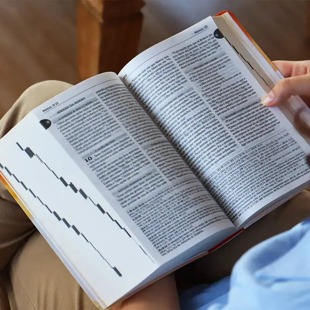 Pessoa lendo a Bíblia aberta com destaque para o texto do Dei Verbum, documento importante sobre a revelação divina na Igreja Católica.